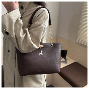 Braune Vintage-Tragetasche mit Goldkette und Hirsch-Anhänger zum beigen Trenchcoat