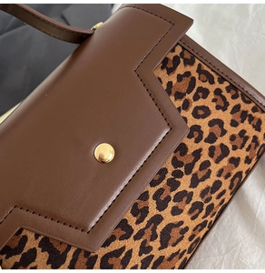 Detail of vintage crossbody bag showing leopard print suede and gold metal buckle