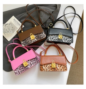 Detail of four leopard print leather crossbody bags in brown, black, pink and caramel