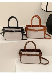 Détail de sacs à main rétro bicolores en trois variantes sur un présentoir blanc épuré