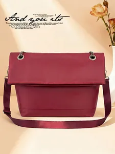 Detailed close-up of wine red nylon crossbody bag with metal chain and wide fabric strap
