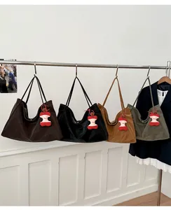 Serie di grandi borse tote in ecopelle in quattro colori con ciondoli a torsolo di mela