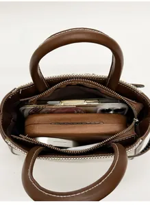 Top view of brown leather handbag interior showing storage capacity for daily essentials