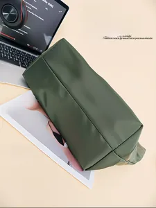 Detailed side view showing the sturdy bottom shape of the dark green tote bag