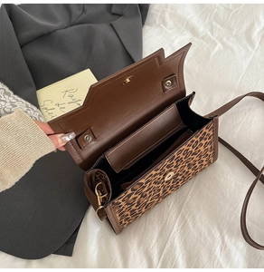 Détail intérieur du sac baguette léopard montrant deux compartiments et fermoir aimanté