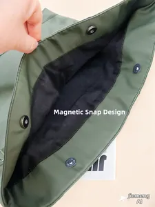 Close-up of dark green tote bag featuring a magnetic buckle closure and black lining