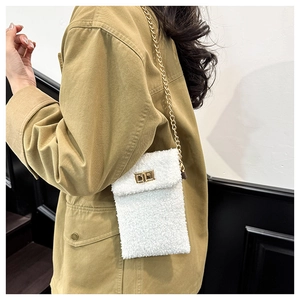 Detailed shot of white plush crossbody bag with golden chain strap and buckle