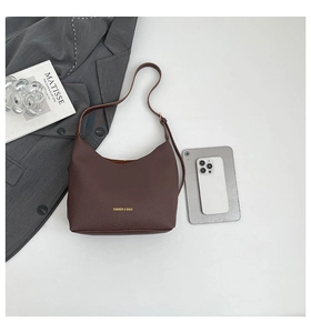 Detail of dark brown lychee leather tote bag with gold logo and size reference