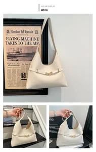 Dettaglio della borsa a tracolla bianca minimalista con fibbia dorata e texture in pelle liscia