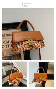 Detail of vintage brown leather bag with leopard print accent and golden padlock closure
