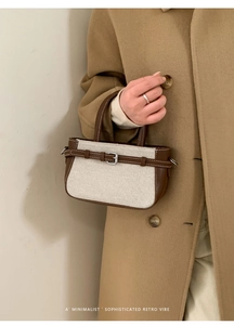 Detail der minimalistischen Retro-Handtasche aus Canvas und Leder am beigen Mantel