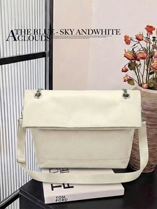 Detail of minimalist cream leather tote bag with elegant metal chain and fabric strap