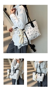 Detailed view of white cartoon tote bag with bunny charm and black strap in daily use