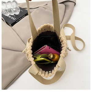 Interior storage view of beige corduroy bucket bag showing wallet and accessories