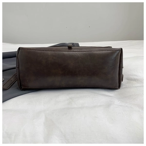 Detail view of the flat bottom on a dark brown vintage PU leather crossbody bag