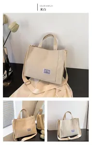 Detail view of off-white corduroy tote bag showing striped texture and brand logo tag