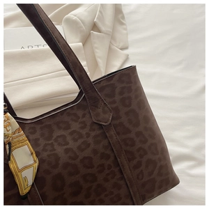 Détail du sac cabas léopard avec foulard vintage sur la poignée et tissu blanc doux
