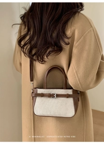 Détail du sac seau rétro minimaliste en toile blanche avec garniture en cuir brun