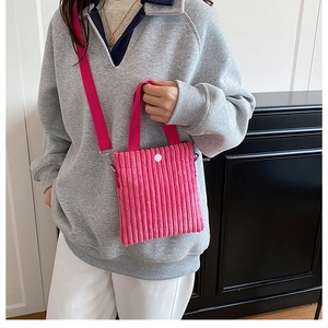 Detailed texture of magenta corduroy mini crossbody bag with button closure