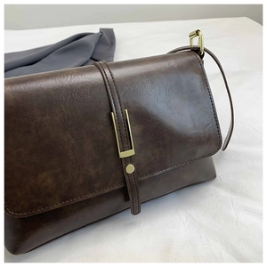 Macro view of dark brown vintage PU leather texture with gold metal buckle details