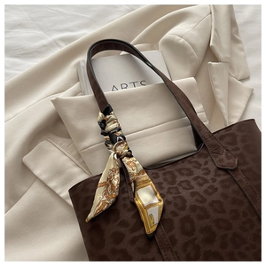 Détail du sac cabas imprimé léopard marron foncé avec foulard en soie sur l'anse