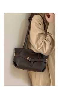 Dettaglio borsa a tracolla in pelle marrone scuro con fibbia su trench coat beige