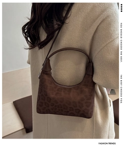 Dettaglio della borsa tote in pelle scamosciata leopardata con manico sottile