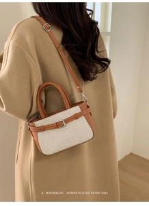 Détail d'un sac seau rétro montrant la texture tissée et les lanières en cuir brun