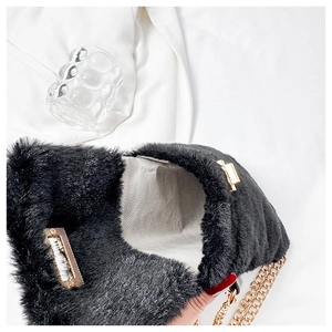 Detail view of black faux fur bag featuring golden chain and herringbone fabric lining