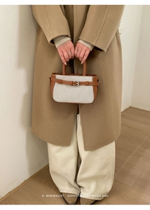Retro-Eimertasche aus Canvas mit braunem Lederbesatz, getragen von einem Modell