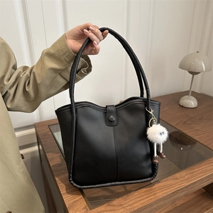 Vintage black faux leather tote bag with plush pendant and contrast stitching detail