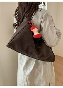 Borsa tote minimalista marrone scuro con ciondolo a mela in peluche indossata da modella