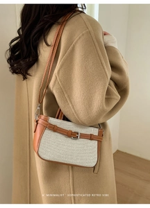 Détail d'un sac à bandoulière tissé beige avec garniture en cuir marron et boucle en métal