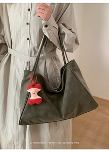 Dettaglio di una grande borsa tote in PU verde oliva con ciondolo a mela in peluche