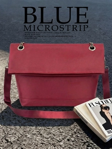 Close-up of wine red oxford cloth shoulder bag with decorative metal rings and wide strap