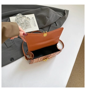 Detail of leopard print crossbody bag with golden twist lock and black lining interior