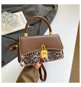 Detail of vintage crossbody bag with leopard print, brown leather flap and gold lock clasp