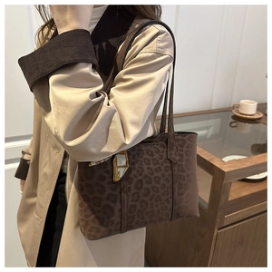 Detail of leopard print tote bag with stylish silk scarf charm on thin shoulder strap