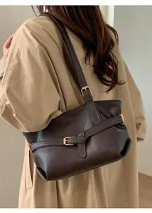 Dettaglio della borsa tote marrone caffè in pelle con fibbia dorata e pieghe morbide