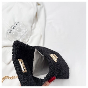 Detail of black faux fur bag with golden twist lock and herringbone fabric lining