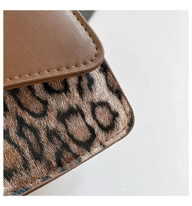 Close-up of vintage shoulder bag featuring brown leather and leopard print textures