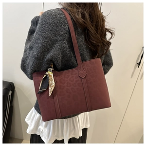 Detail of burgundy leopard print tote bag with printed silk scarf on the handle