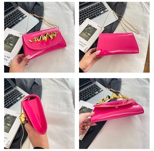 Detailansicht einer rosa Lackleder-Box-Tasche mit goldenen gewellten Metallakzenten