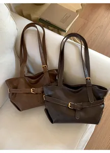 Dettaglio di borse tote in pelle vintage con cinturino a fibbia e finiture dorate