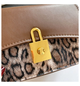 Detailed macro view of the retro dark brown leather flap and leopard print texture on the bag