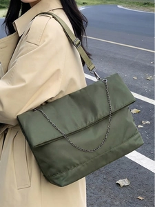 Detail of army green large capacity tote bag with silver chain and wide textile strap