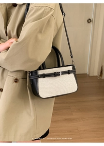 Détail du sac seau en toile contrastée avec garniture en cuir noir et boucle en métal