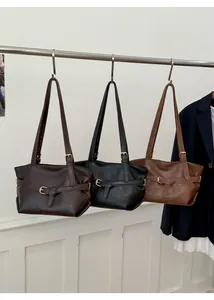 Dettaglio di borse tote minimaliste in caffè, nero e cuoio con fibbia decorativa