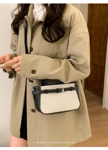 Sac seau minimaliste en toile avec bordure en cuir noir porté à l'épaule