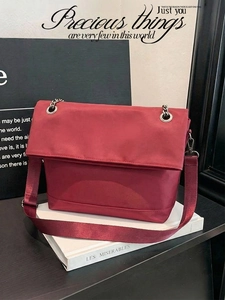 Detailed view of dark red tote bag with silver eyelets and hybrid chain strap